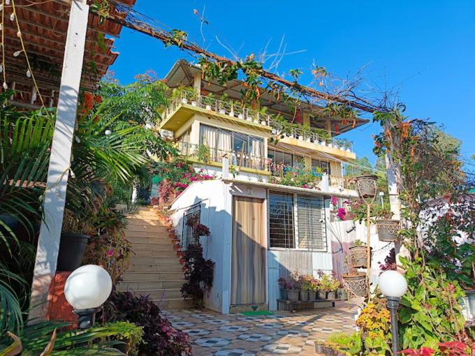 una casa con flores a un lado. en Strawberry County, en Panchgani