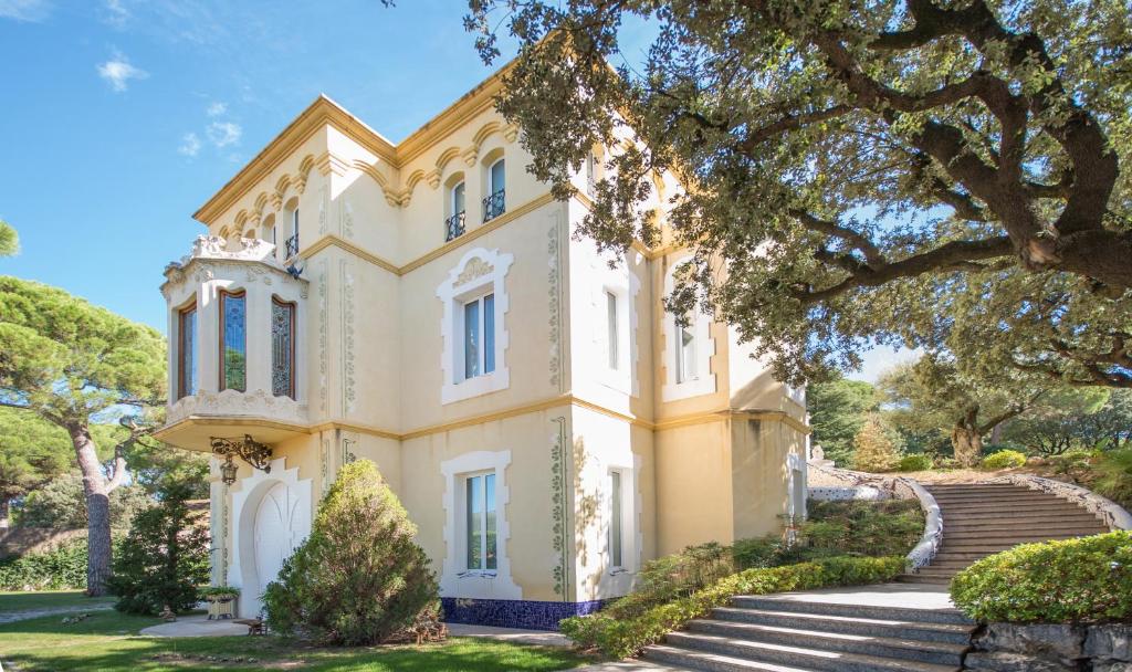 una casa con una escalera delante de ella en Hotel Boutique Edelweiss La Garriga, en La Garriga