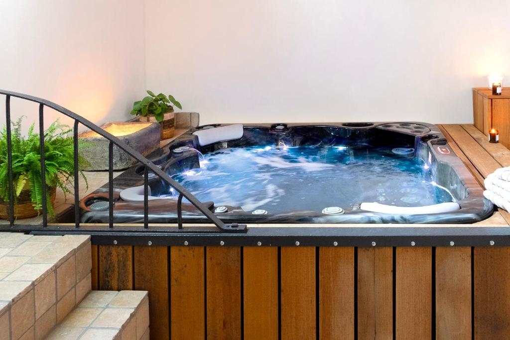 a jacuzzi tub sitting on top of a deck at Suite & SPA à La Ferme 1802 in Sainghin-en-Mélantois