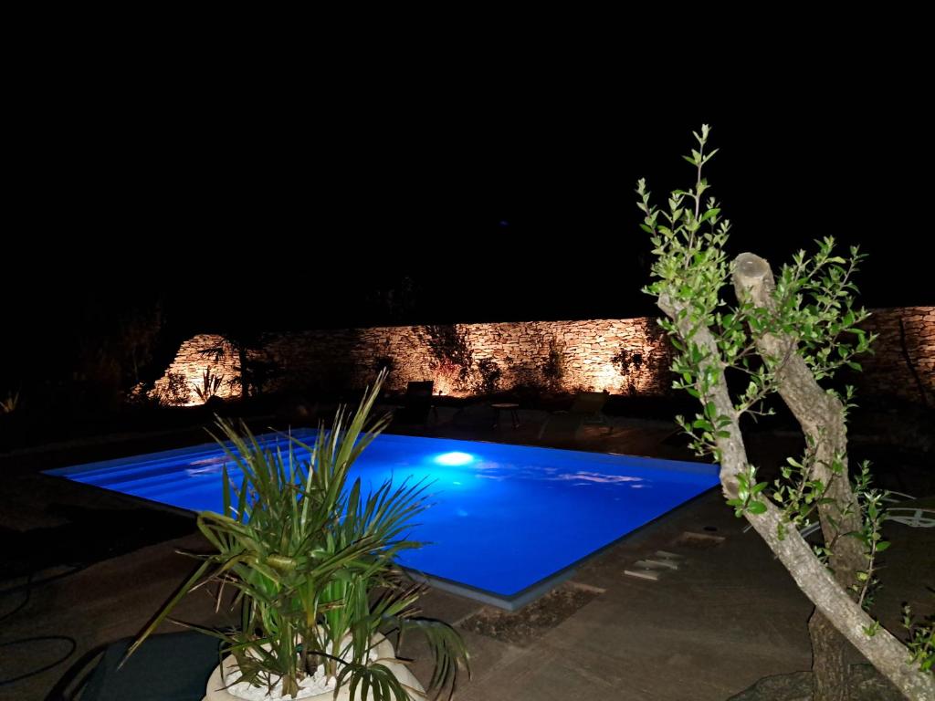 uma piscina iluminada à noite em Maison au calme idéalement située proche plage em Bonifacio