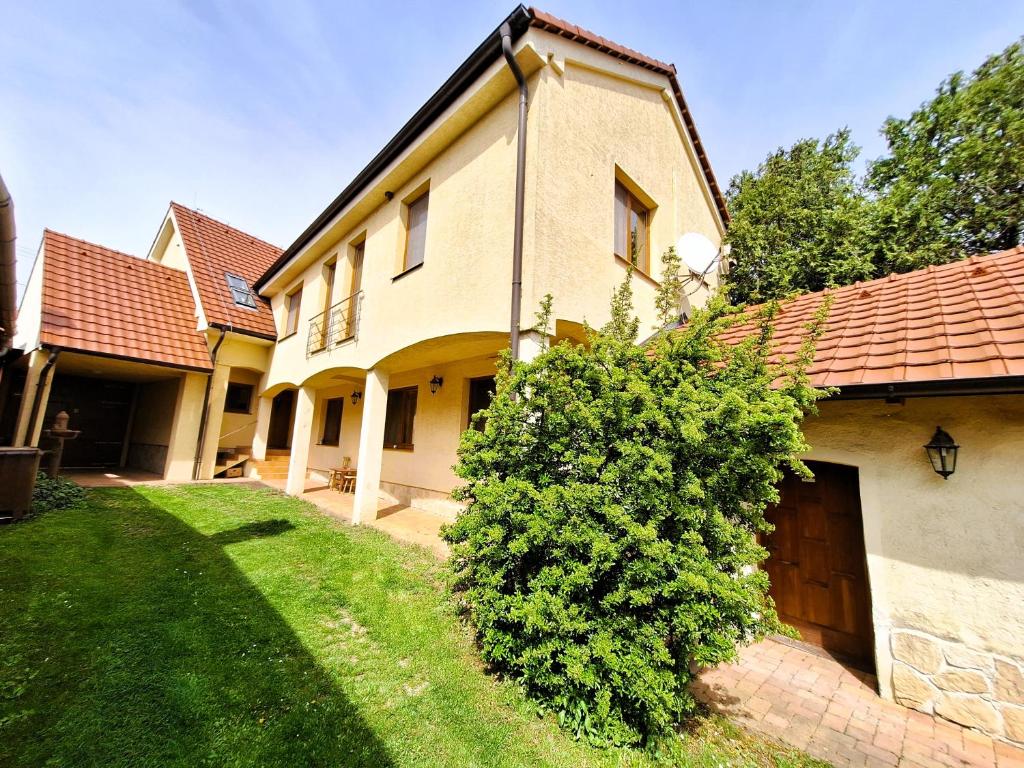 una grande casa con un cortile con un cespuglio di Penzión Villa Agnes a Smolenice