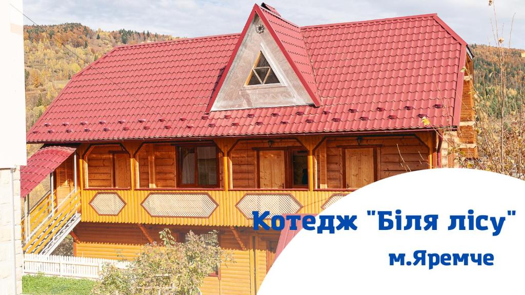 una gran casa de madera con techo rojo en Котедж Біля лісу, en Yaremche