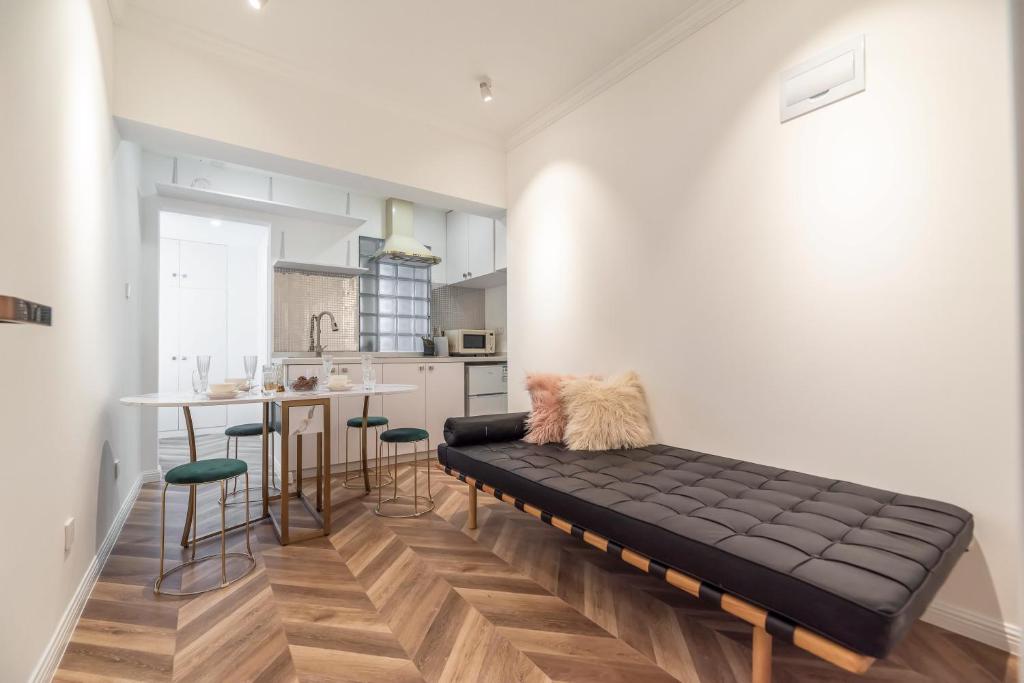 a living room with a black couch and a kitchen at Shanghai Hills & Serendipity MCM Near Line1 & Line2 People's Square in Shanghai