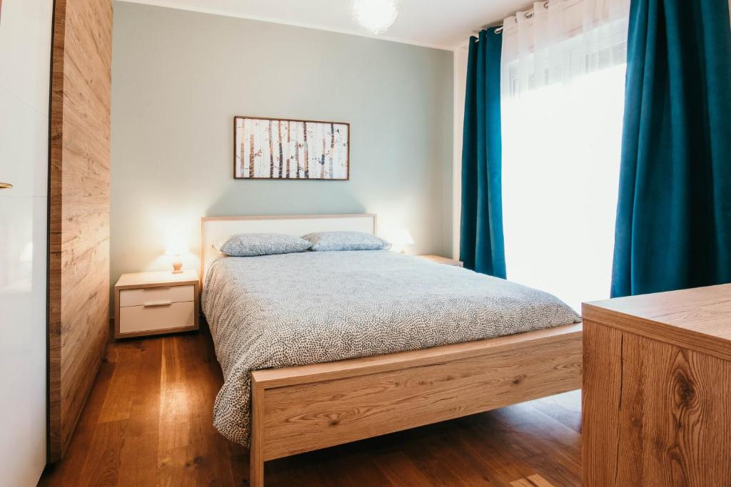 una camera da letto con letto e tende blu di Da Mario - Lakeside SRL Leisure & Business ad Arona