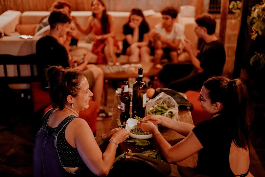 um grupo de pessoas sentadas à volta de uma mesa a comer em Berat Backpackers Hostel em Berati