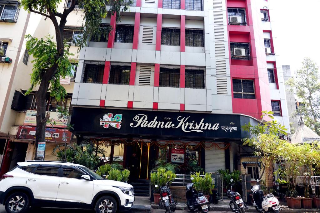 Hotel Padma Krishna في بيون: سيارة بيضاء متوقفة أمام مبنى