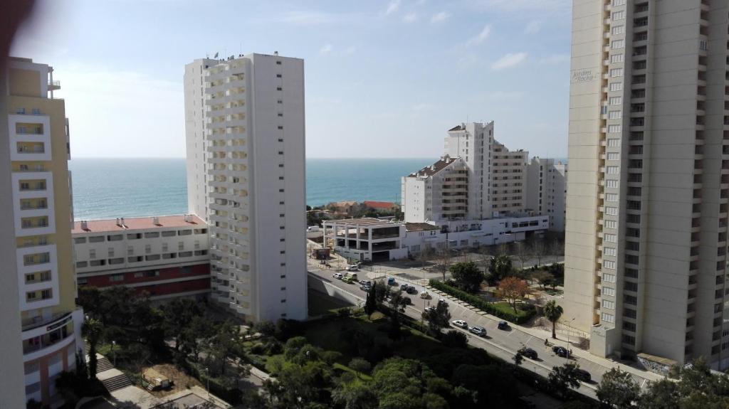 uma vista para uma cidade com edifícios e o oceano em Rocha T Apartments em Portimão