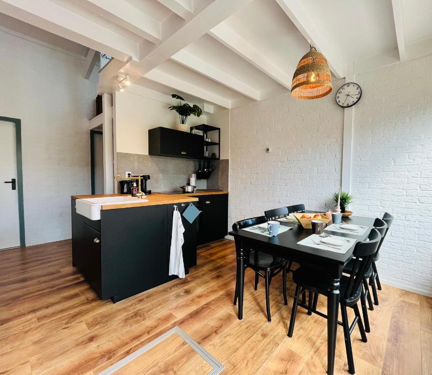 a kitchen and dining room with a black table and chairs at Bos Water Huisje Veluwemeer in Biddinghuizen