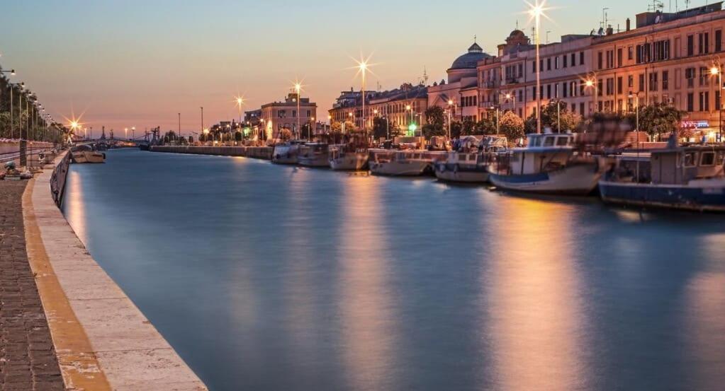 a river with boats in a city at night at Sweet Home FCO Airport Roma in Fiumicino