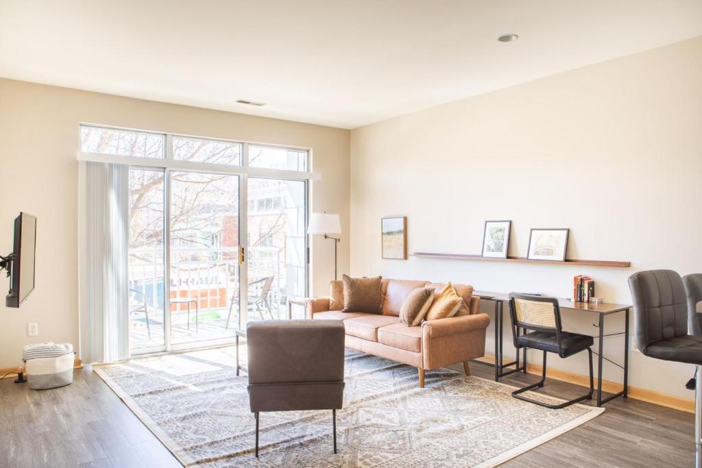 uma sala de estar com um sofá e uma cadeira em Flexhome Brewers Hill 1BR TS1 - near Brady St and Riverwalk em Milwaukee