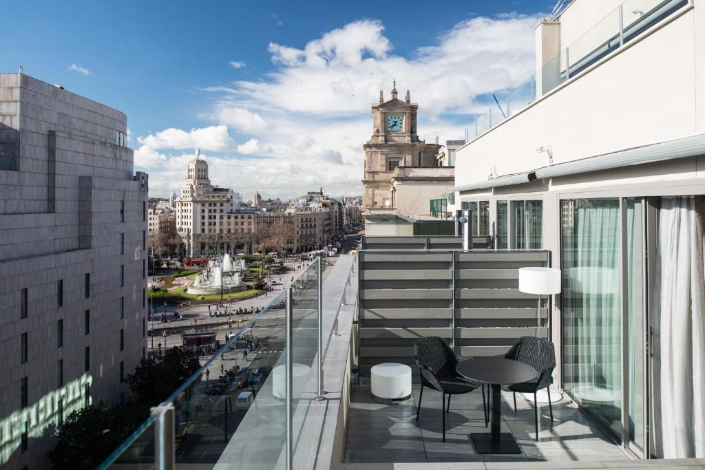 einen Balkon mit einem Tisch und Stühlen auf einem Gebäude in der Unterkunft Catalonia Square 4* Sup in Barcelona