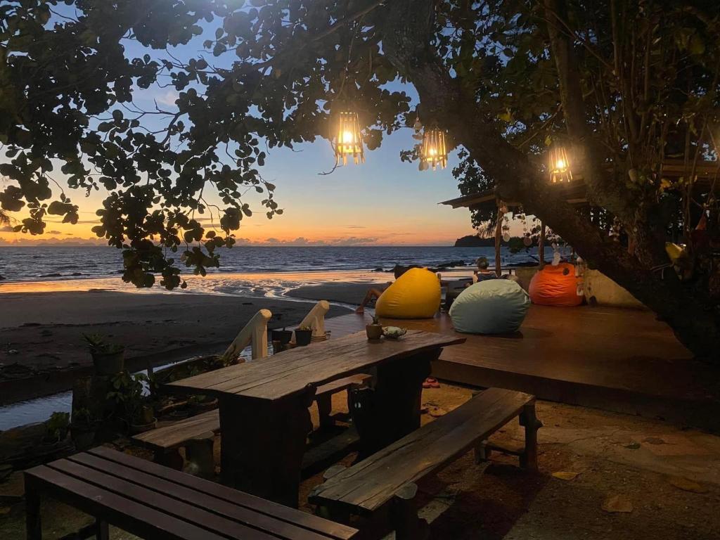 una mesa de picnic en la playa con puesta de sol en Coconut Lanta Resort @Klong Dow beach, en Krabi