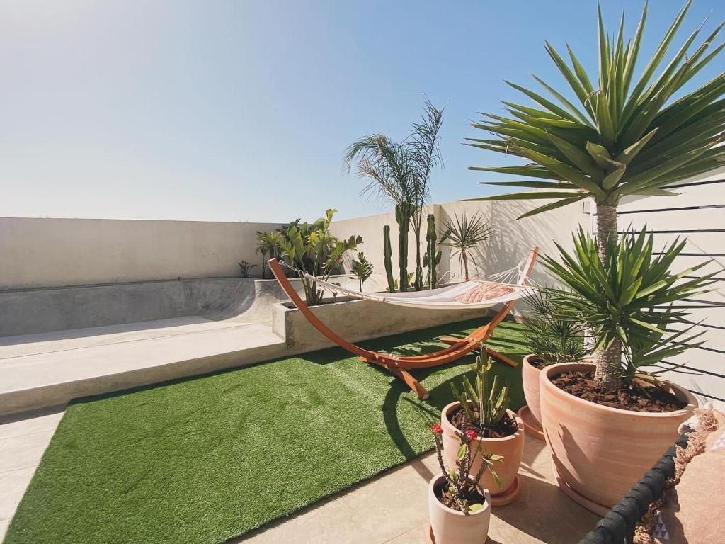 um pátio com uma rede de descanso e plantas numa varanda em Casa Biota em Sagres