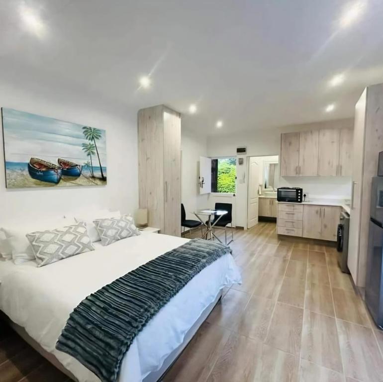 een slaapkamer met een groot bed en een keuken bij Avonlea Guest House in Kloof