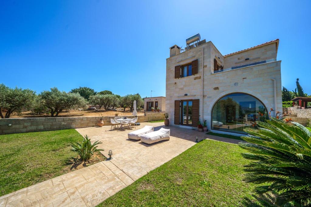 un gran edificio de piedra con patio en FOS residence - ΦΩΣ ,luxury villa, en La Canea