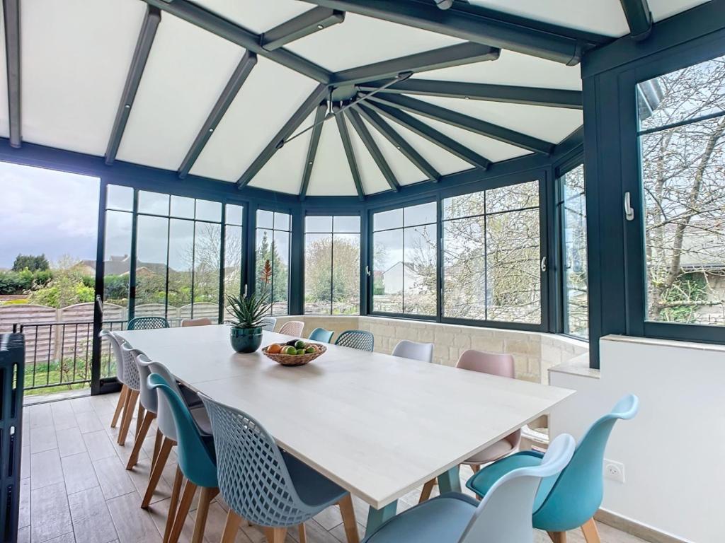 une salle à manger avec une table et des chaises blanches dans l'établissement Gite "Chez Eléonore et Axel", à Gouvieux