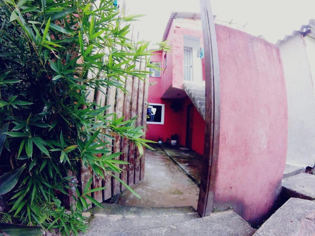 Une allée avec un bâtiment rouge et des plantes dans l'établissement Casa do Aventureiro, à Abraão