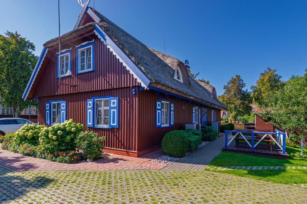 une maison rouge avec un toit en gambrel dans l'établissement Vila Banga, à Nido