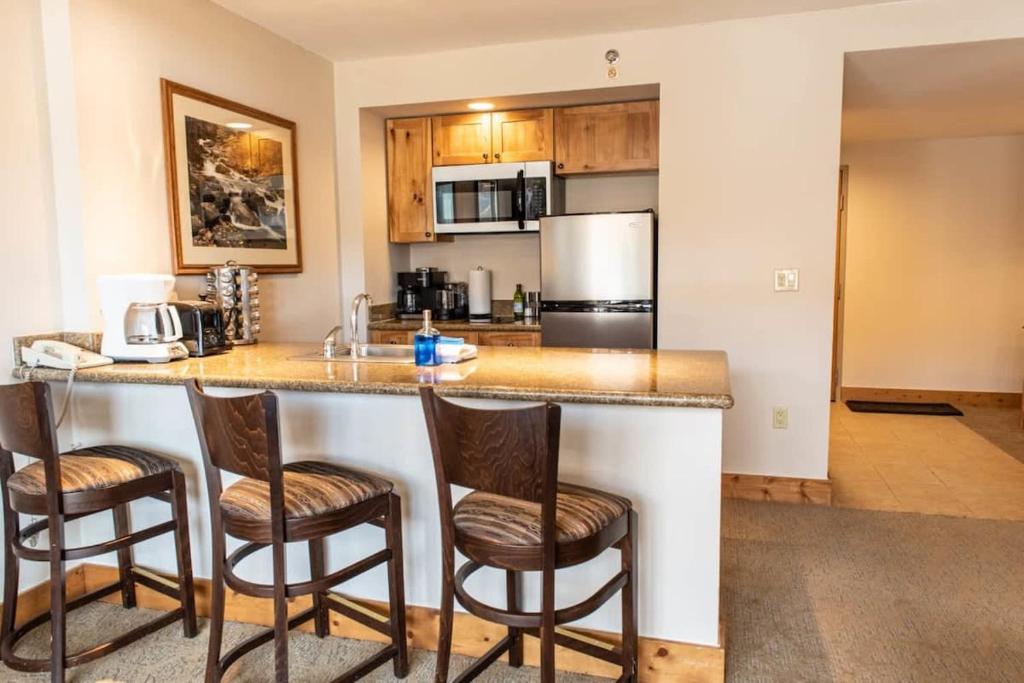 une cuisine avec un comptoir et 4 chaises autour de celle-ci dans l'établissement 1bd SUITE 504 Perfect Location with Pool and Hot Tub, à Crested Butte