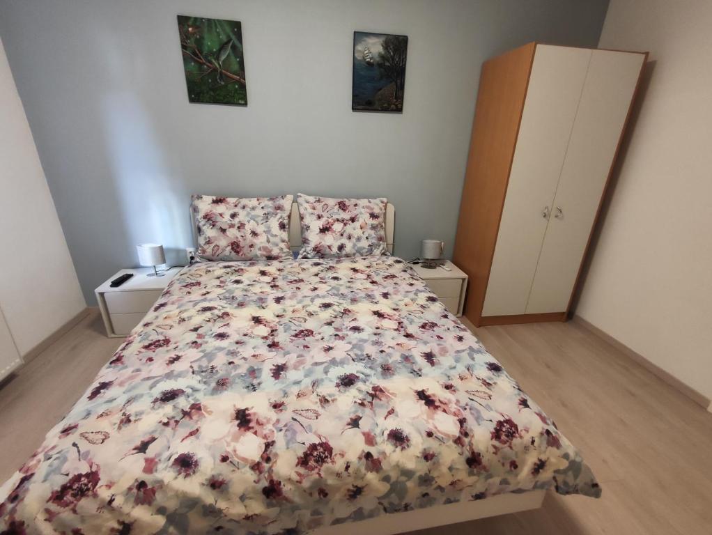 1 Schlafzimmer mit einem Bett mit Blumenbettdecke in der Unterkunft Kuća za odmor EMA in Šibenik