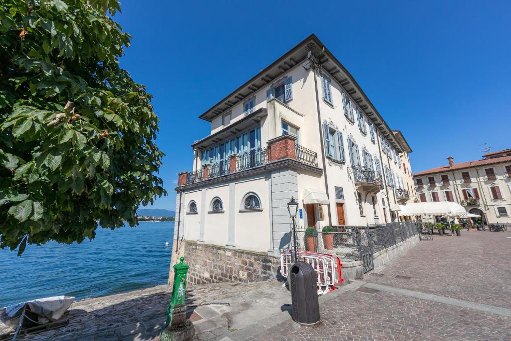 ein Gebäude an der Seite eines Wasserkörpers in der Unterkunft Aparthotel Arona - Happy Rentals in Arona