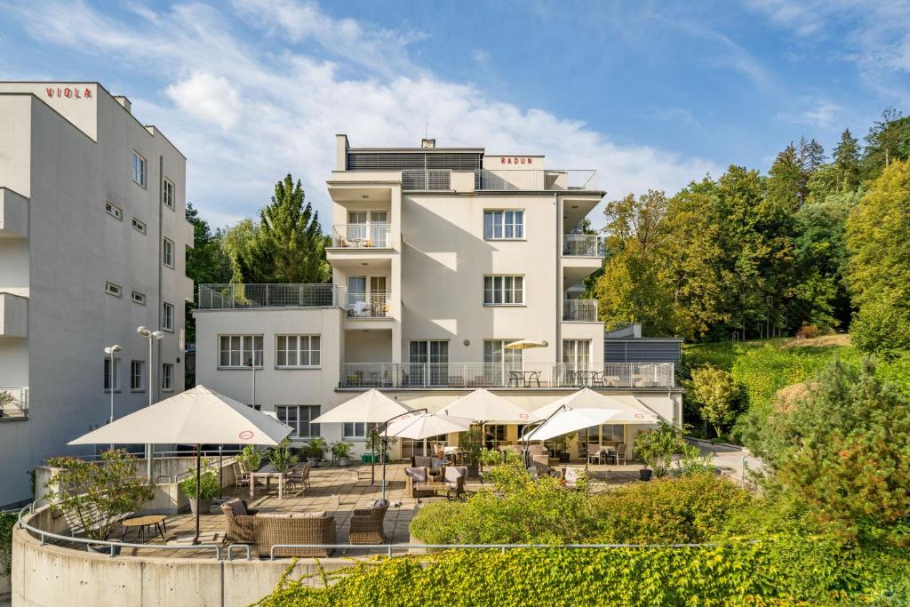 een uitzicht op een hotel met tafels en parasols bij Hotel Radun in Luhačovice