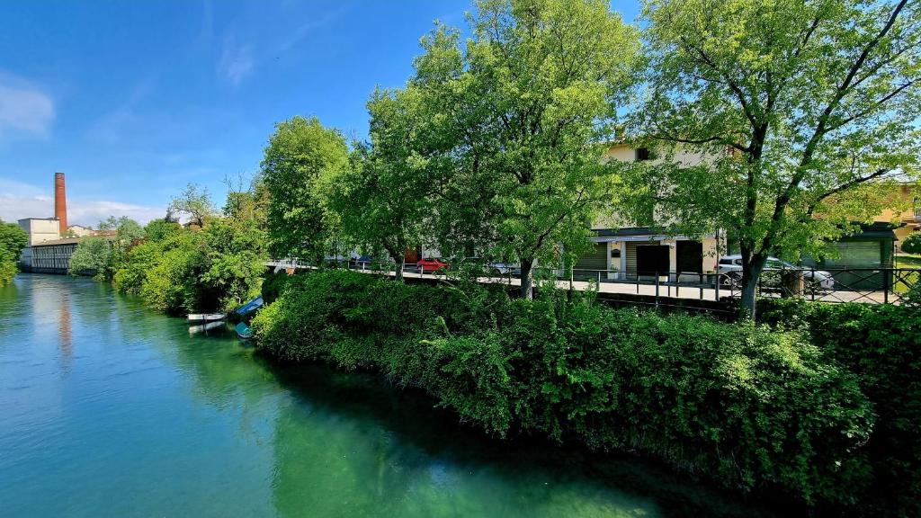 un río con árboles a su lado en Botanique Hotel Vergani, en Fara Gera dʼAdda