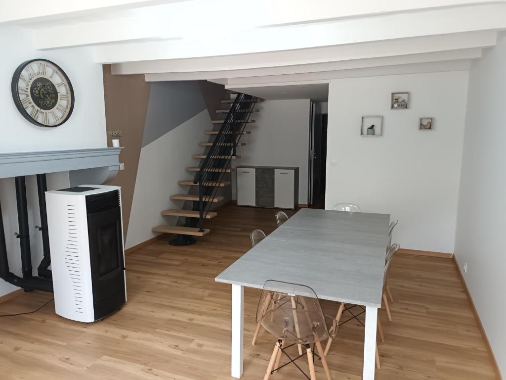 une salle à manger avec une table et un escalier dans l'établissement Gîte des deux petits doudous, à Colombey-les-Deux-Églises