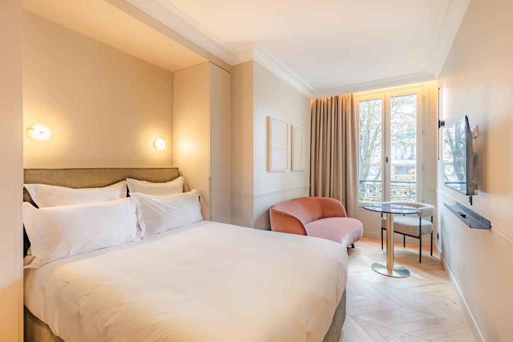 Habitación de hotel con cama y silla en Maison du Moulin Vert, en París