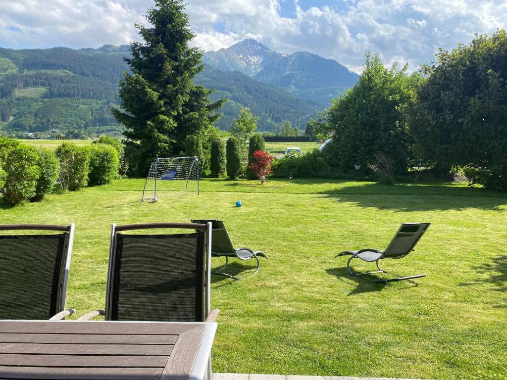 ツェル・アム・ゼーにあるChalet Panoramablick Zell am Seeの山の田場の椅子2脚とベンチ