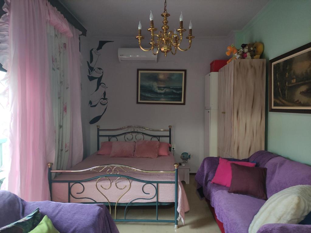 een slaapkamer met een bed, een bank en een kroonluchter bij Kalys House in Kavala