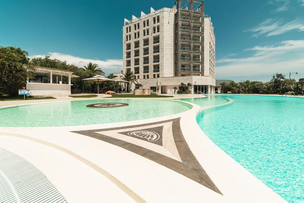 a large swimming pool with a building in the background at Delta Hotels by Marriott Olbia Sardinia in Olbia