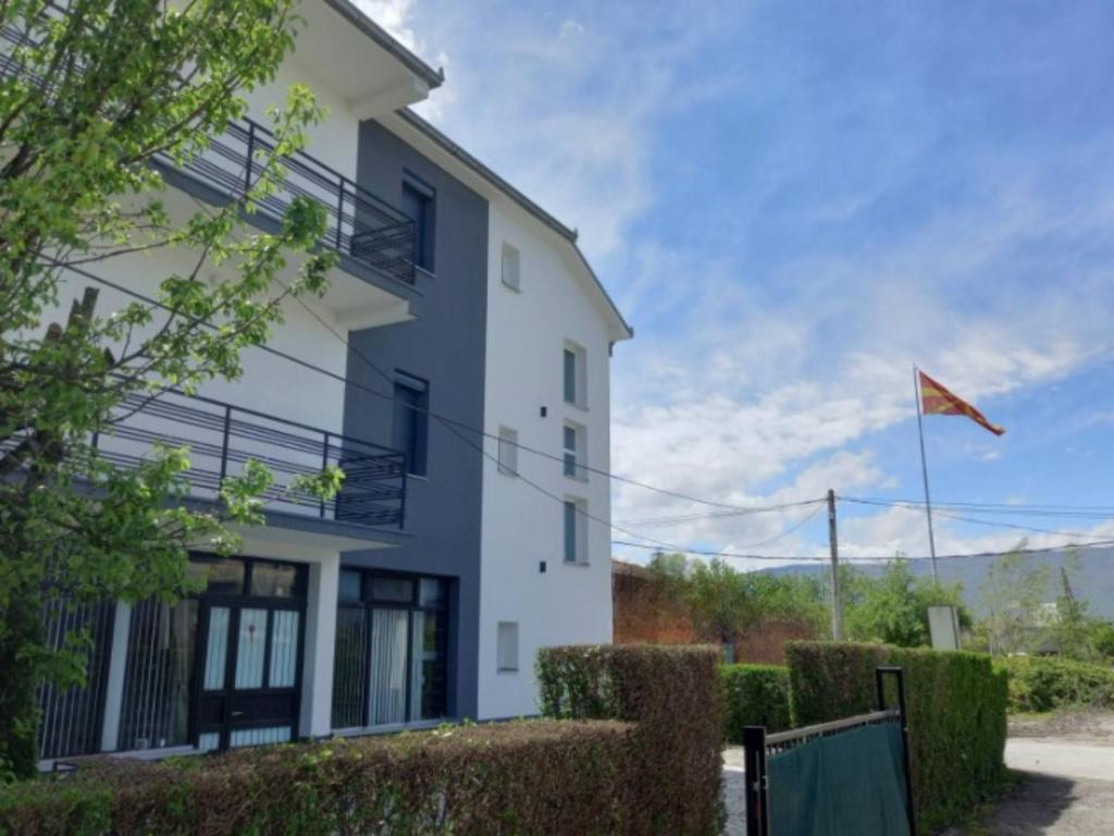 een wit gebouw met een vlag ervoor bij Ambient Apartments in Struga