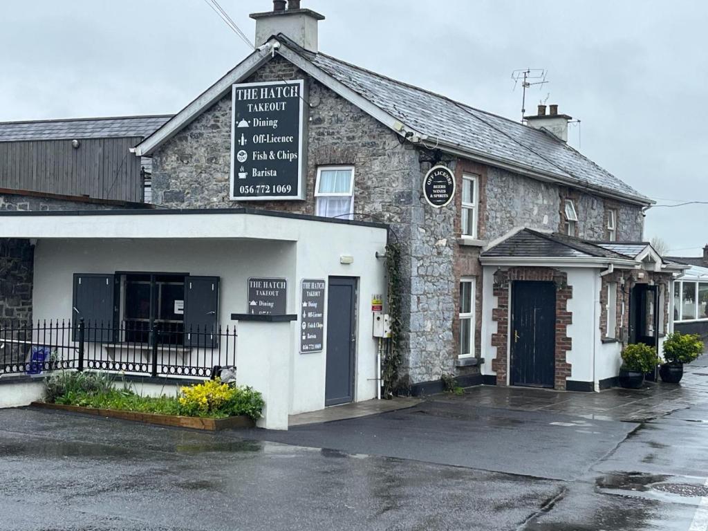 een oud stenen gebouw met een bord erop bij Glendine Inn in Kilkenny