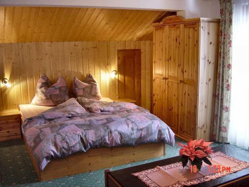 een slaapkamer met een bed in een houten kamer bij Villa Sorgenfrei in Gaschurn