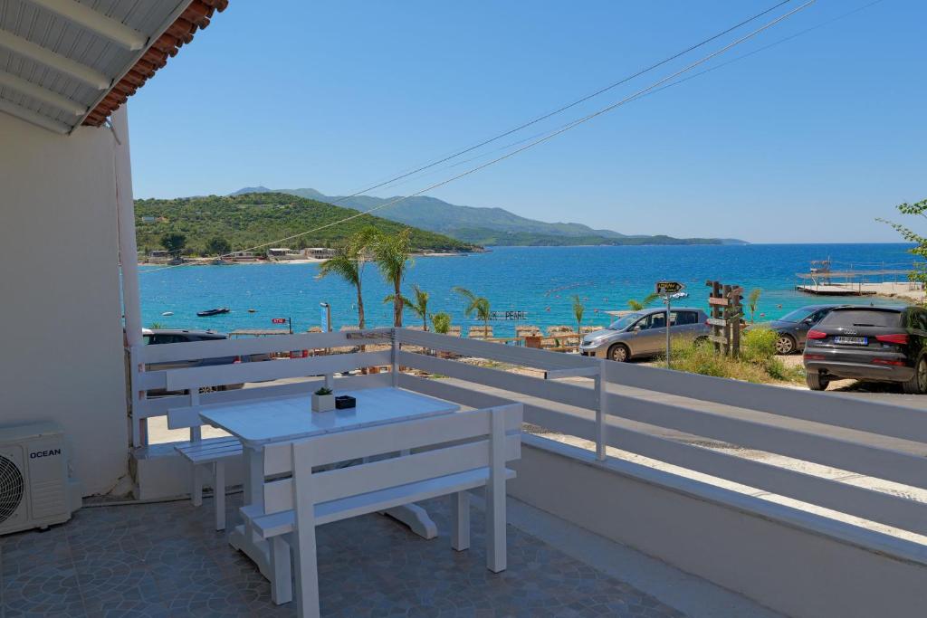 - une table blanche sur un balcon avec vue sur l'océan dans l'établissement Livia's Guesthouse, à Ksamil