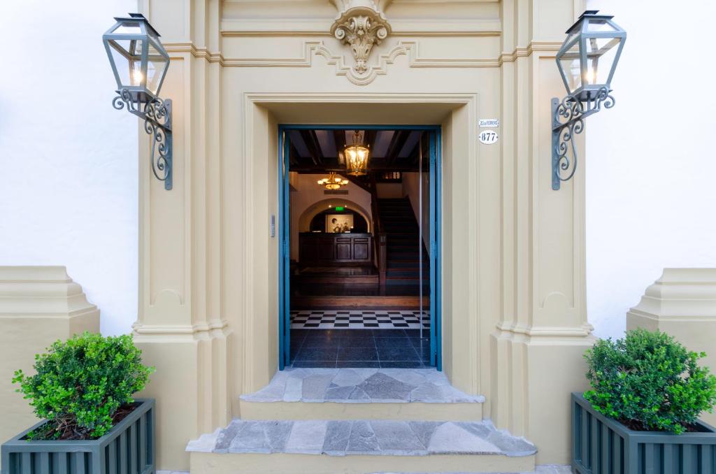 una entrada a un edificio con dos macetas en El Bodeguero Hotel, en Salta