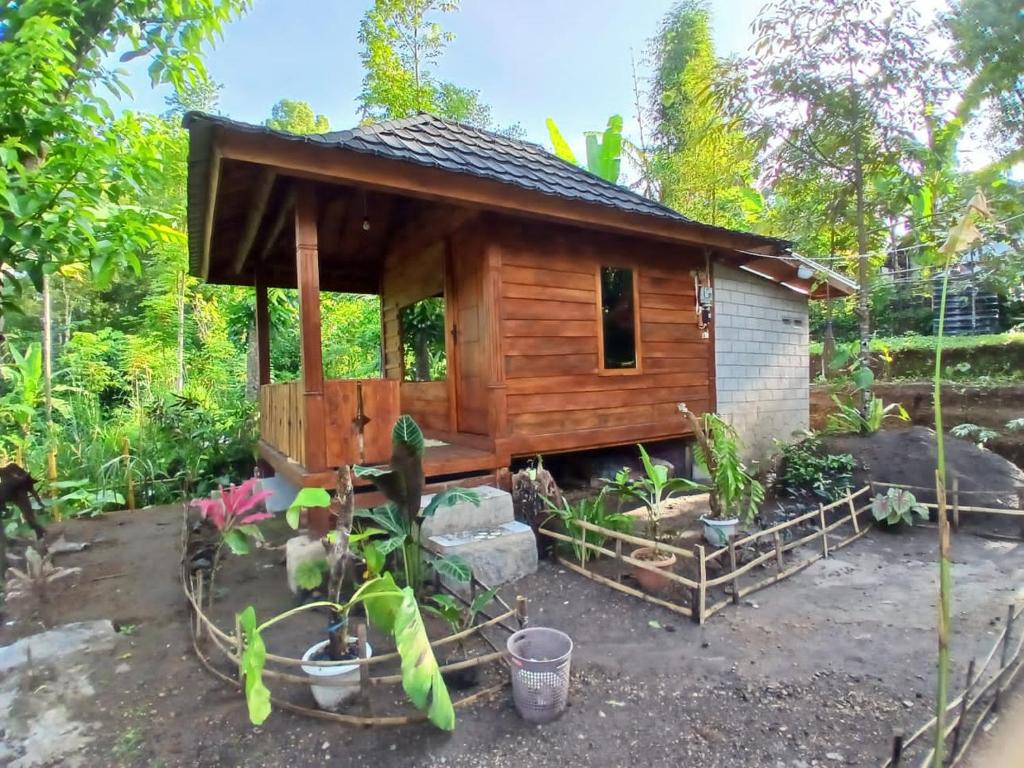 a small wooden cabin in a garden at MY HOME tetebatu in Tetebatu