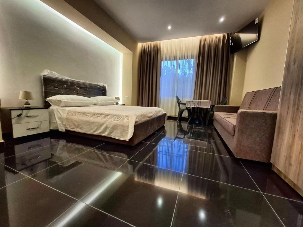 a hotel room with a bed and a couch at CityCenterHotel Shkoder in Shkodër