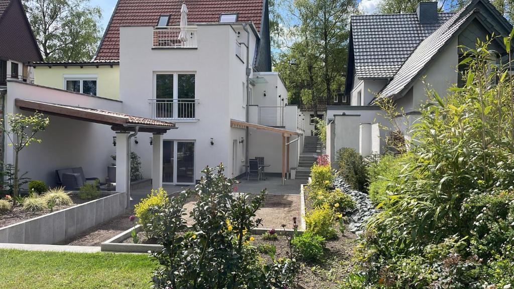 una casa blanca con un jardín delante de ella en City Wohnung mit Gartenblick und Dachterrasse, en Verden