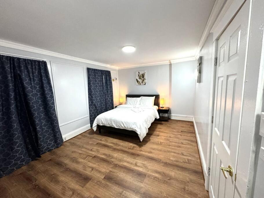 a bedroom with a white bed and a wooden floor at Getaway at Falls-3 Beds-Slips 6 in Niagara Falls