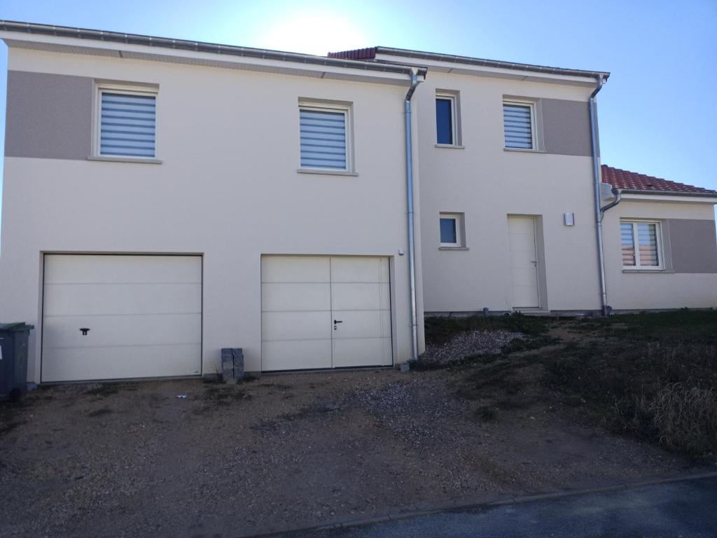 una casa bianca con quattro porte del garage di Aux pieds de la colline de Mousson a Pont-à-Mousson