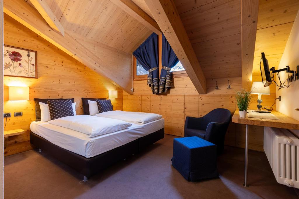 - une chambre avec un lit dans une pièce en bois dans l'établissement Hotel Cardo, à Valdidentro