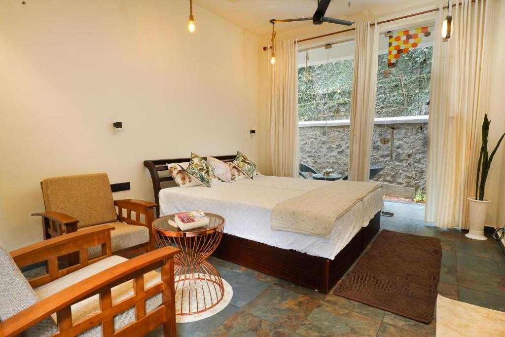 una camera con letto, divano e finestra di Mickey Homestay a Thekkady