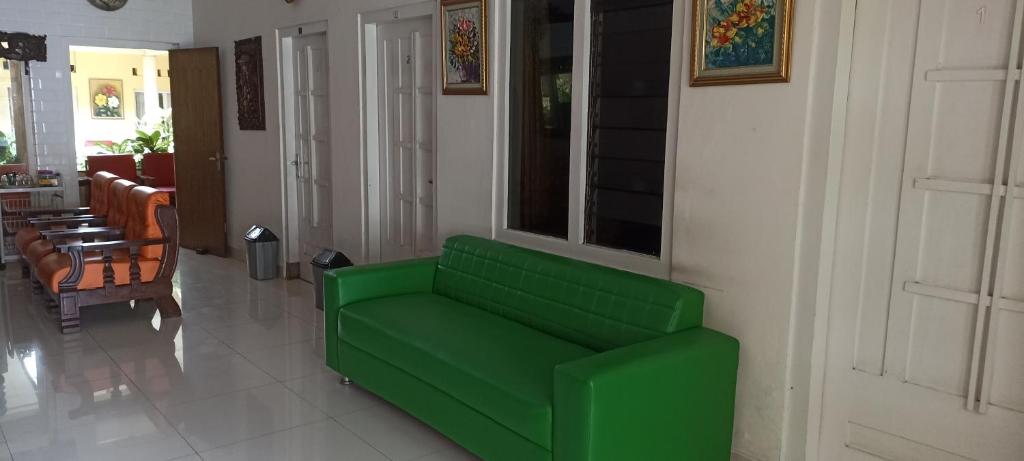 ein grünes Sofa im Wohnzimmer in der Unterkunft Prayogo Lama Prawirotaman in Yogyakarta