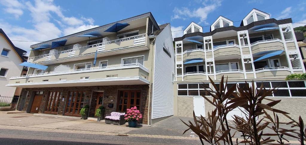 een groot wit gebouw met bloemen ervoor bij Strandhaus an der Mosel in Valwig