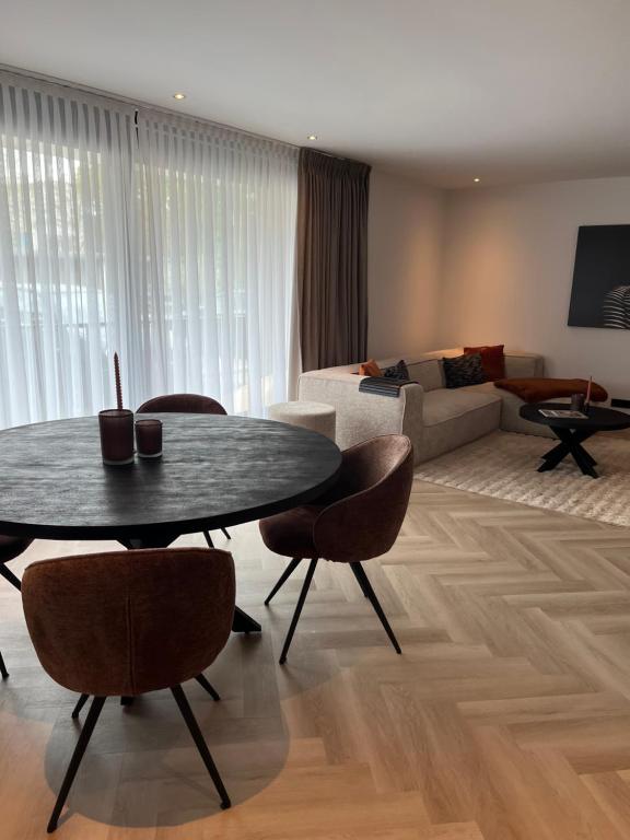 uma sala de estar com uma mesa e cadeiras e um sofá em Boulevard 3F em Arnhem