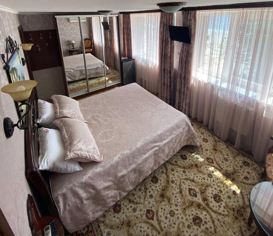 een slaapkamer met een bed en een grote spiegel bij Shalanda in Odessa