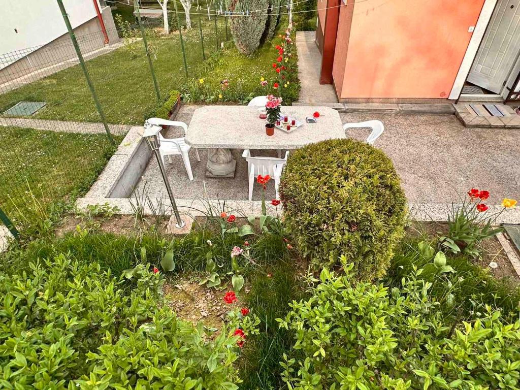 un tavolo e sedie in un giardino fiorito di Villa Bella a Ilidža