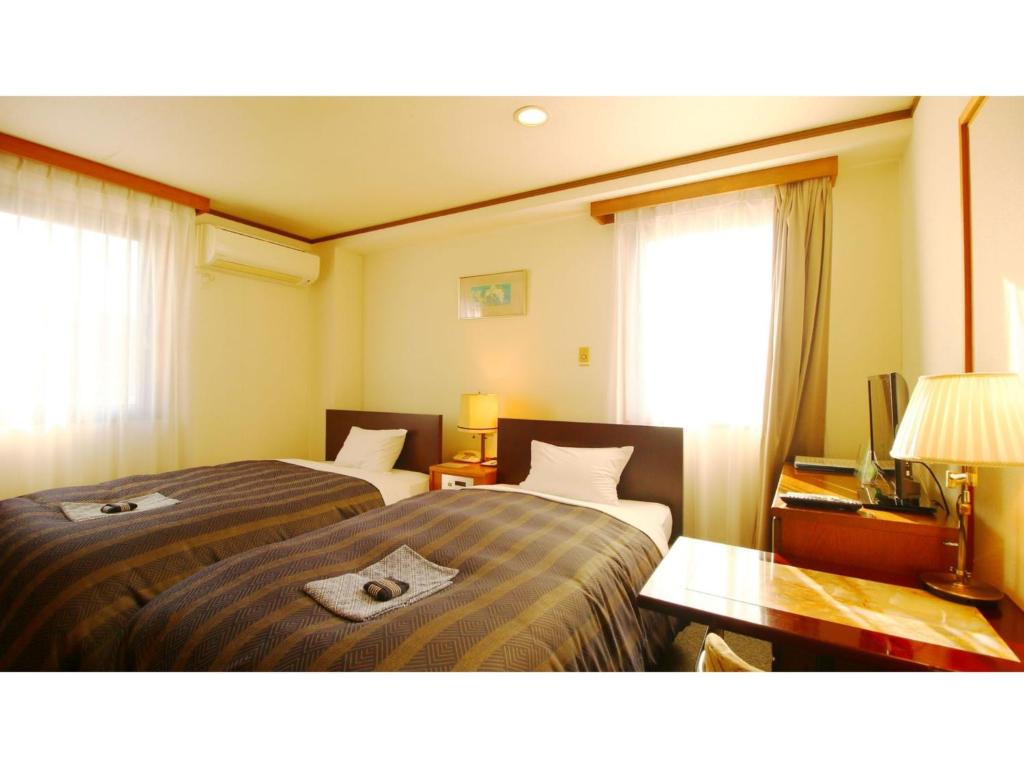 um quarto de hotel com duas camas e uma mesa em Hotel Itakura - Vacation STAY 70112v em Fukushima